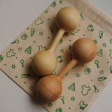 Two wooden baby rackets on a patterned mat with green baby-related illustrations.