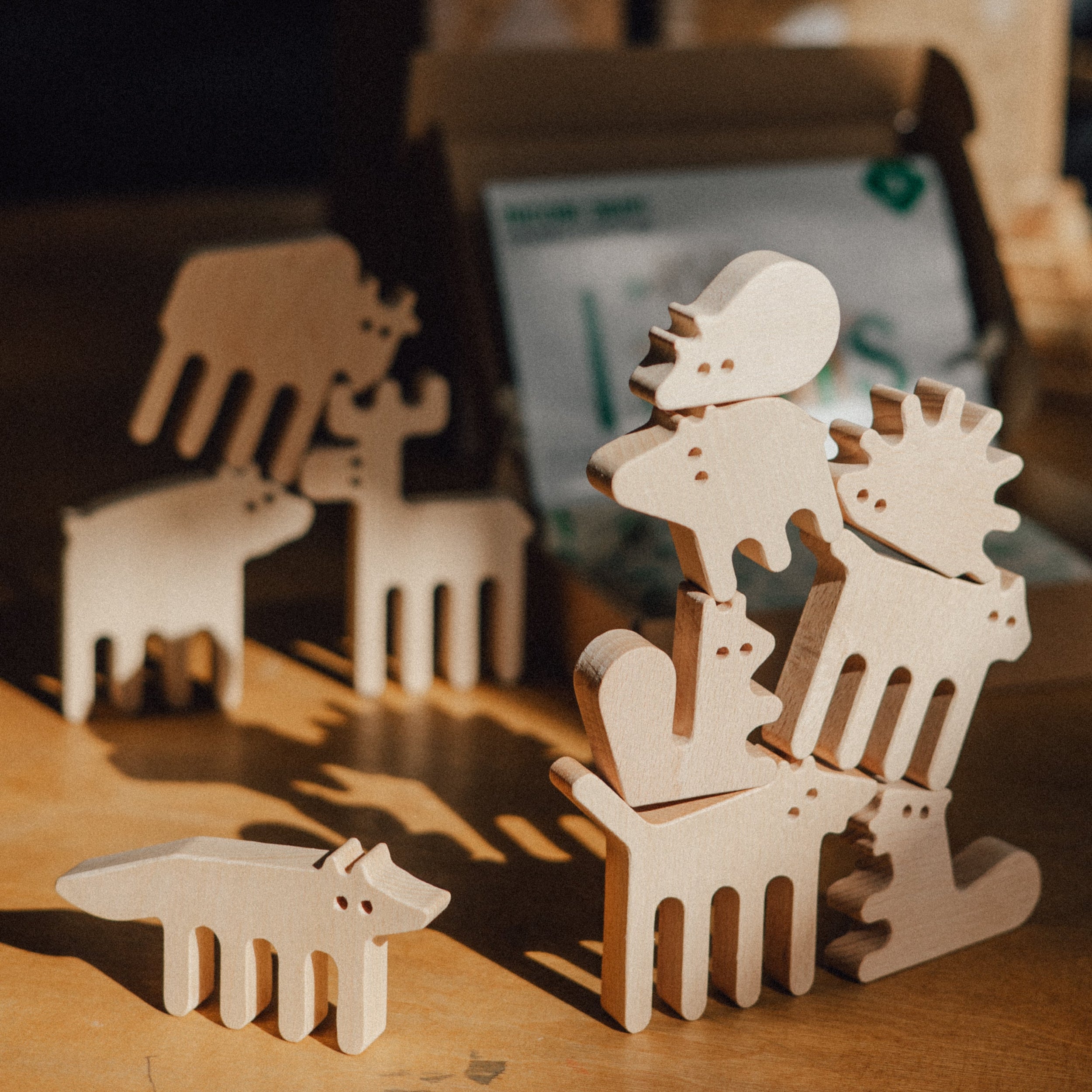 Wooden animal figurines on a wooden surface with a blurred background