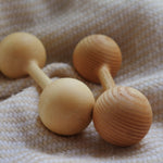 Two wooden dumbbells on a textured fabric background
