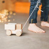 Дитина тягне деревʼяну машинку lislis